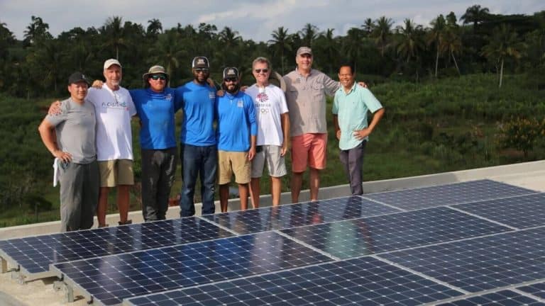 Freedom Solar's team in front of solar panels installed on roof of orphanage in Haiti
