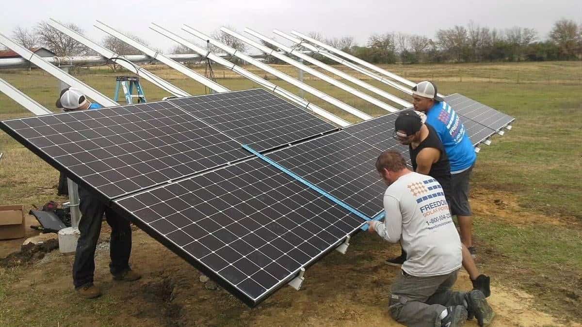 Men installing solar panels above ground