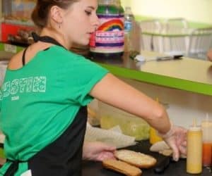 Woman making sandwich from Thundercloud Subs company