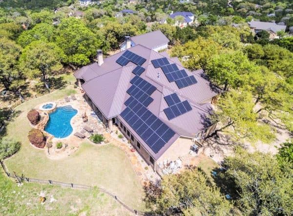 Aerial view of large house with solar panels on roof