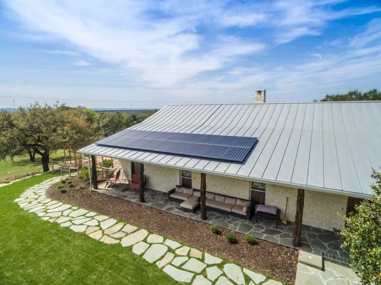 Solar panels on roof of house in Prado Crossing, Boerne, Texas under bright blue sky