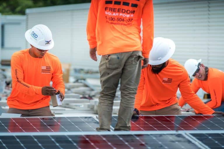 Freedom Solar's team installing sola panels on roof
