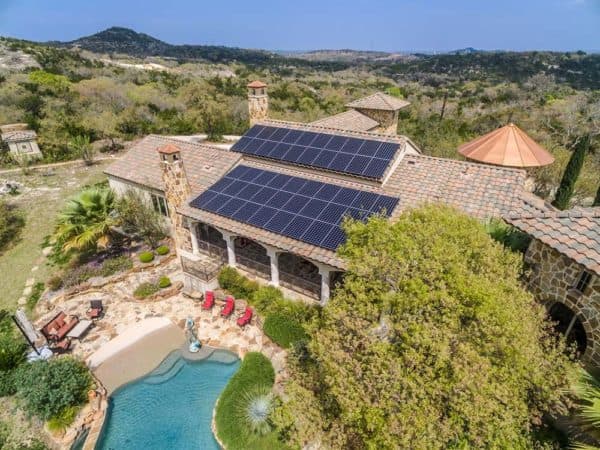 View of the back of the house in Scenic Loop, San Antonio, Texas with solar panels installed on roof and backyard view