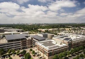 Drone view of Strictly Pediatrics Surgery Center in North Central Austin with solar panel array installed and city view