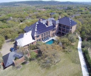 Side drone view of house with solar panels, pool and surrounded and backyard view in Arbutus Cove, Austin, Texas