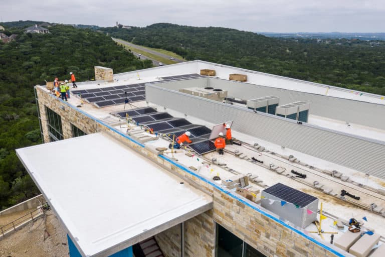 Close-up roof view of Davenport building with man installing solar panels