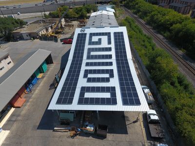 Side view of solar panels forming the word "guido" over rooftop