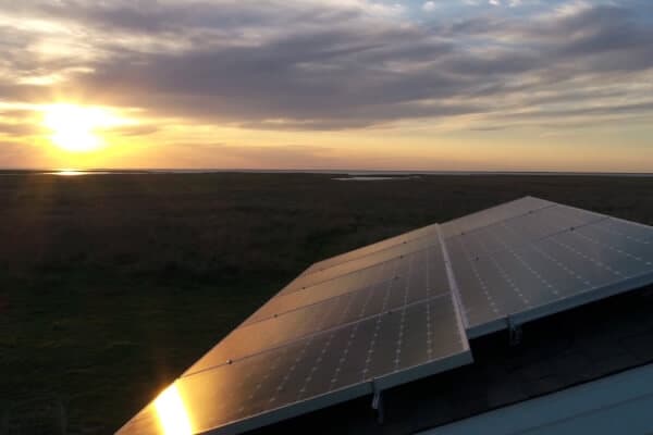 House roof in Matagorda, Texas with solar panels installed on the roof during sunset