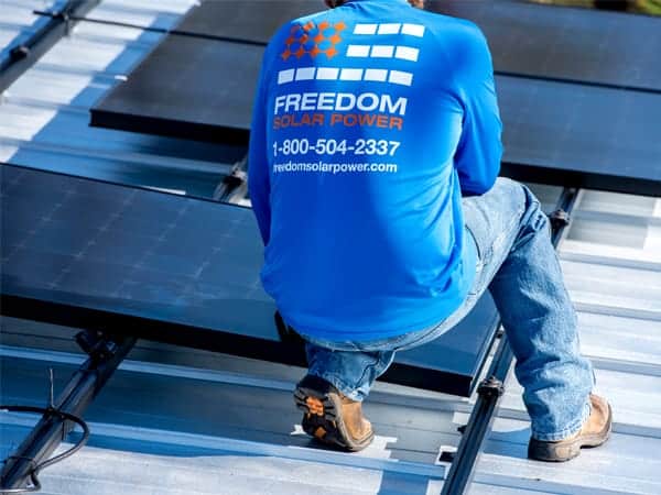 Freedom Solar technician installing solar panel on roof