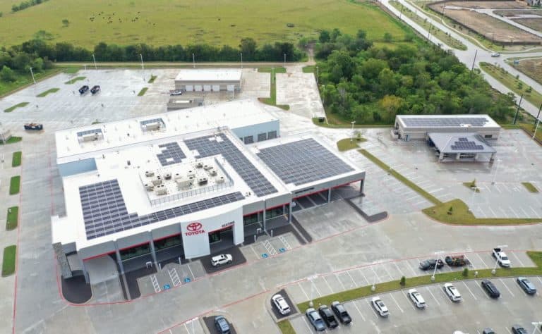 Aerial view of solar panels installation on Keating Toyota building in Alvin, Texas and green areas