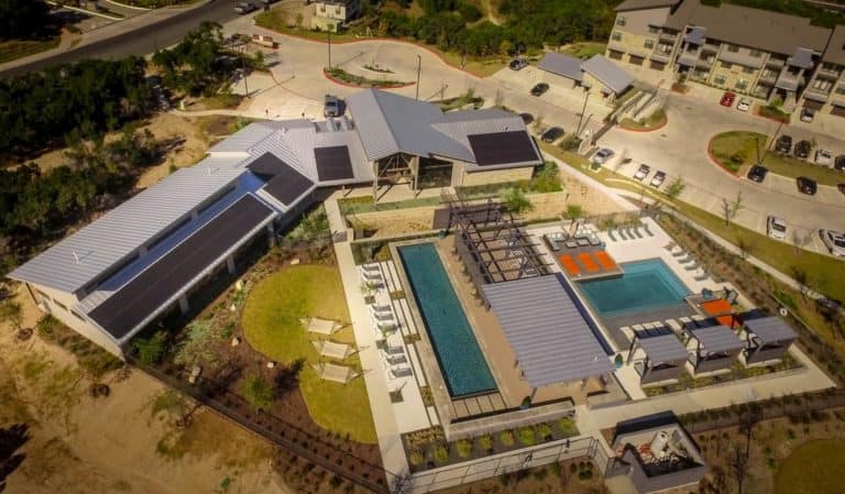 Aerial view of building with swimming pools and solar panels on the roof in Lantana neighborhood