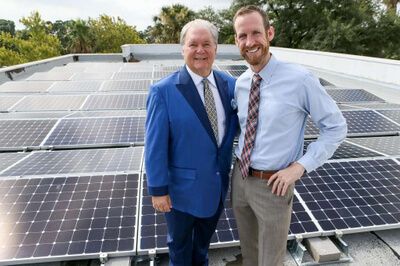 CEO of Mission Park Funeral Chapels & Cemeteries, Dick Tips and Freedom Solar's Director of Sales, Kyle Frazier on roof with solar panels installed