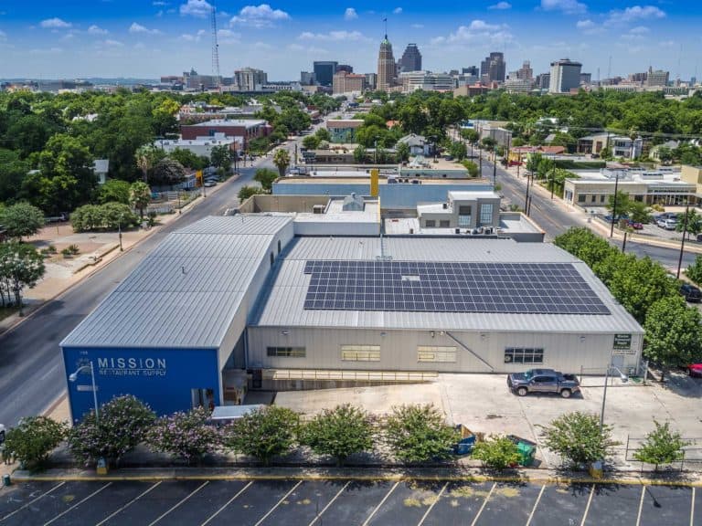 General view of Mission Restaurant Supply in McAllen, Texas with solar panels on the roof and downtown behind