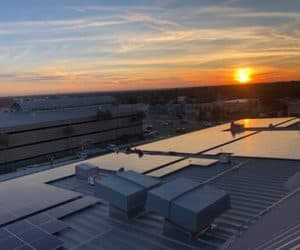 Drone roof view of The Northtown Professional Plaza in Laredo with array of solar panels installed and sunset in the back