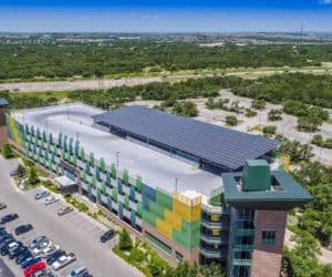 Entrance drone view of Northwest Vista College in San Antonio, Texas with solar panels installed on roof and green areas in the back