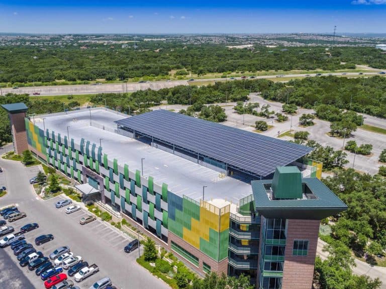 Entrance drone view of Northwest Vista College in San Antonio, Texas with solar panels installed on roof and green areas in the back