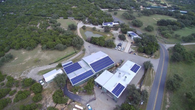 Drone view of Rehme building with solar panels on the roof and green areas around