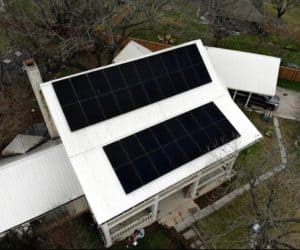Drone view of house in Houston, Texas with solar panels installed on roof and backyard view