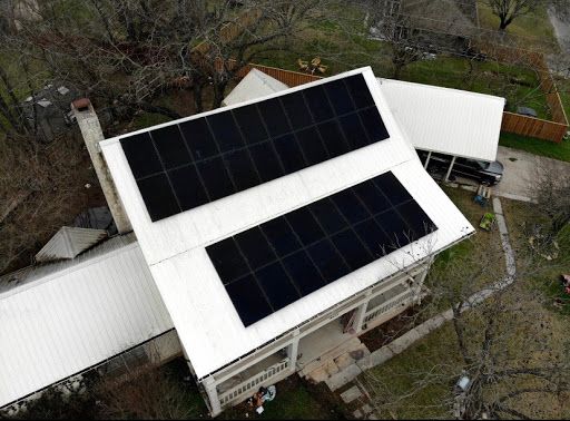Drone view of house in Houston, Texas with solar panels installed on roof and backyard view
