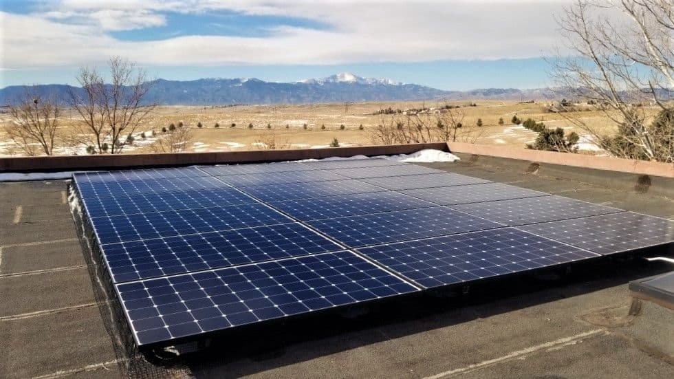 Solar panels installed on roof of a house in Peyton, Colorado and mountains in the back
