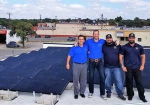 Freedom Solar's team on roof of commercial building with solar panels installed