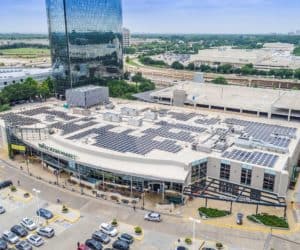 Whole Foods Market's building in Dallas, Texas with solar panels installed on roof and commercial buildings around