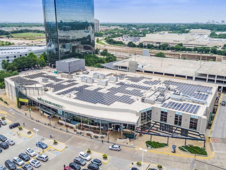 Whole Foods Market's building in Dallas, Texas with solar panels installed on roof and commercial buildings around