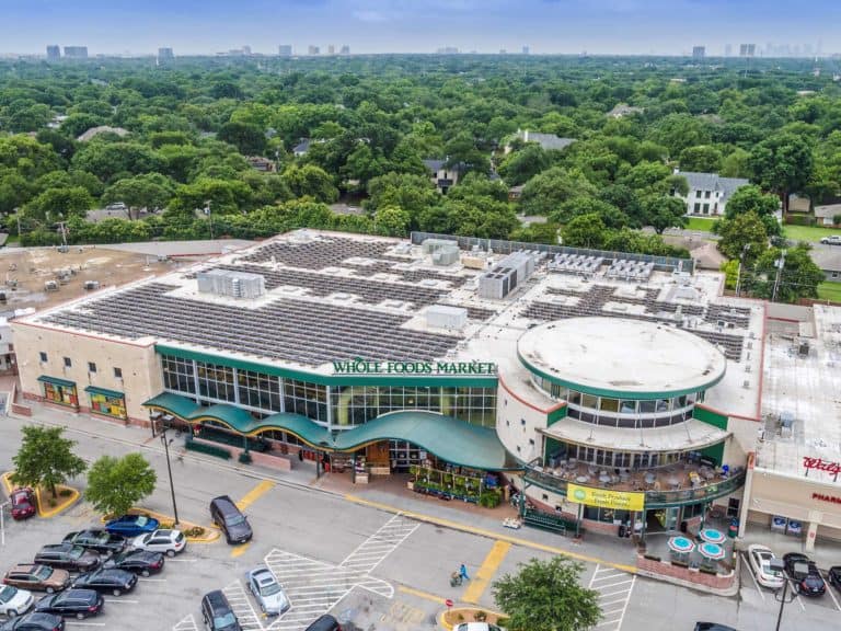 Aerial frontal view of Whole Foods Market in Dallas, Texas with array of solar panels installed on roof