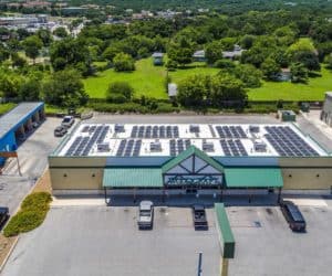 Front aerial view of Woodcraft commercial building in San Antonio, Texas with solar panels on roof and green areas in the back
