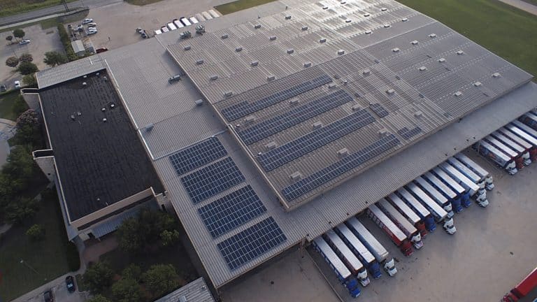 Aerial view of Brown Distributing Company roof with installed solar panels and parked trailers
