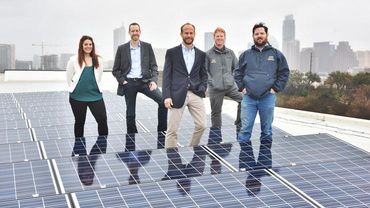 Freedom Solar's team standing on top of roof with solar panels