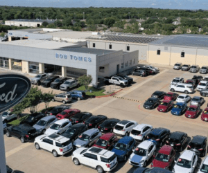 Bob Tomes Ford dealership in McKinney, Texas with solar panels installed on roof and parking lot view