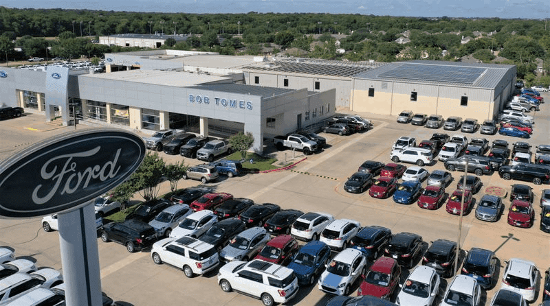 Bob Tomes Ford dealership in McKinney, Texas with solar panels installed on roof and parking lot view