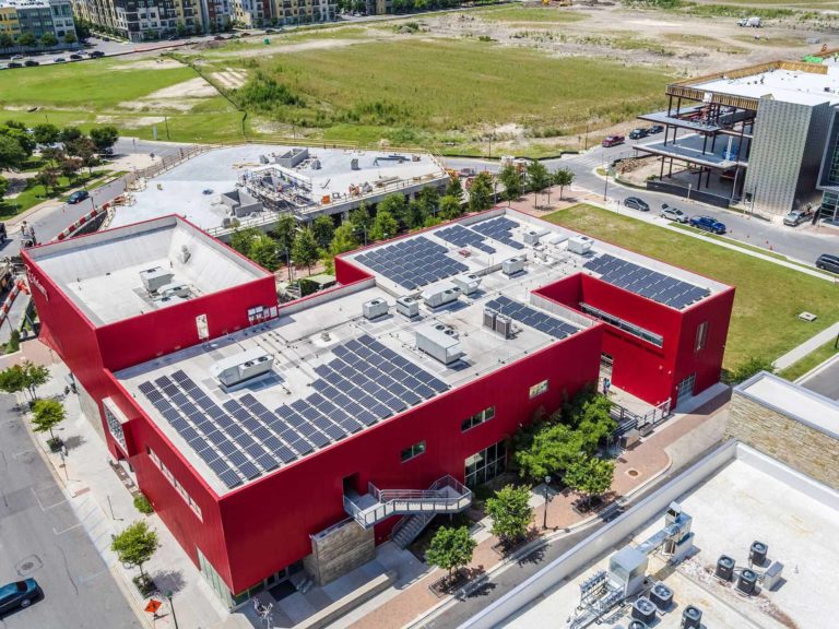 Solar panels on the roof of the Thinkery Museum and grass in the background