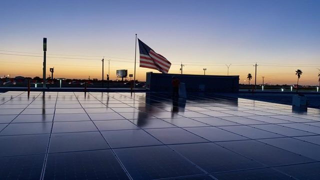 Roof view with solar panels at sunset and usa flag