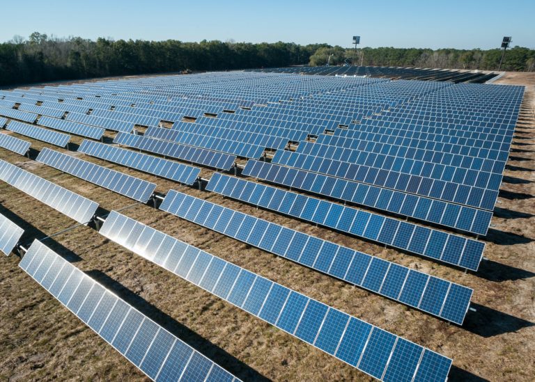 Multiple rows of solar panel arrays in an open field to generate wide-scale solar energy.