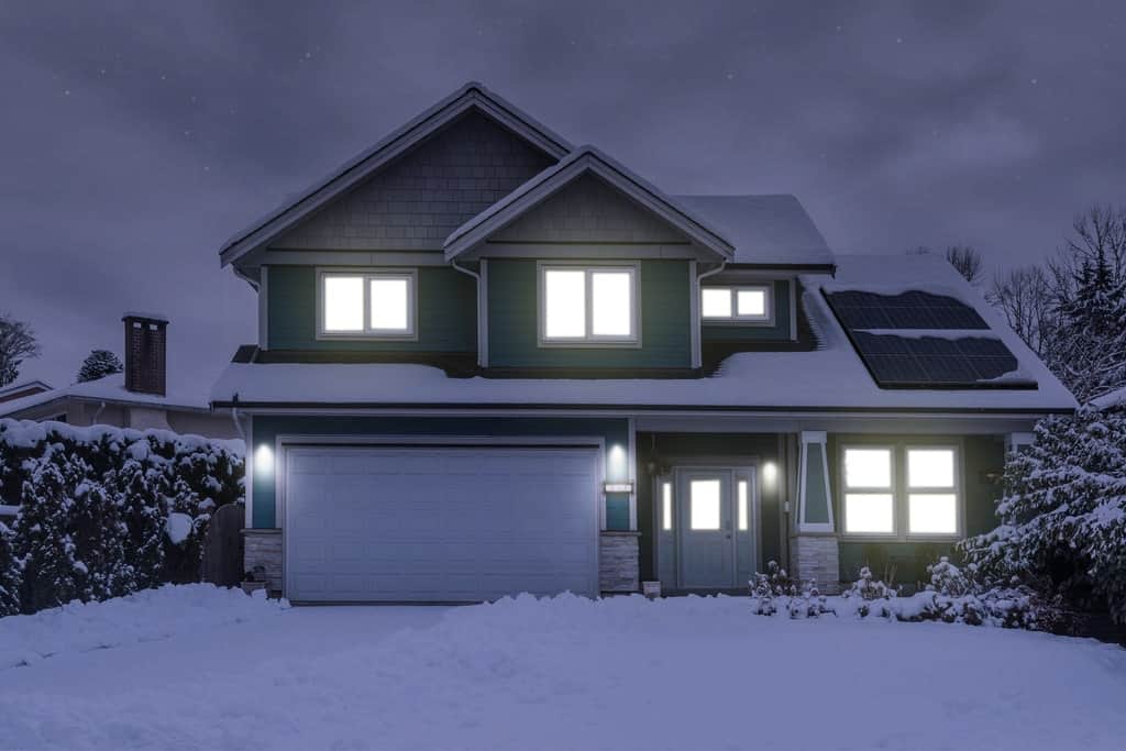home in the snow with solar panels on roof