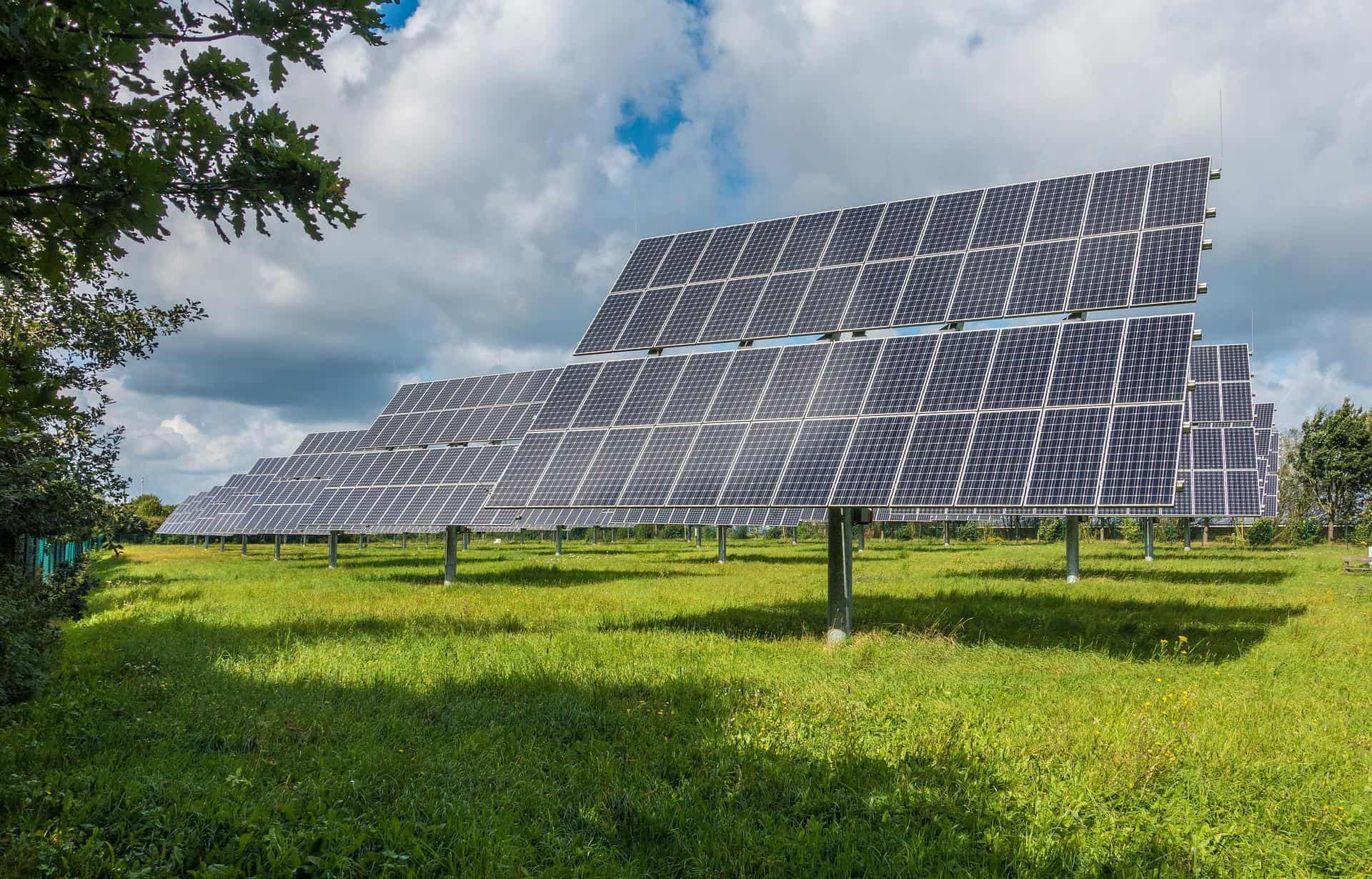 A solar panel array installed in a field pictured during a bright and sunny day.