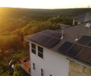 sunset over house with solar panels on roof