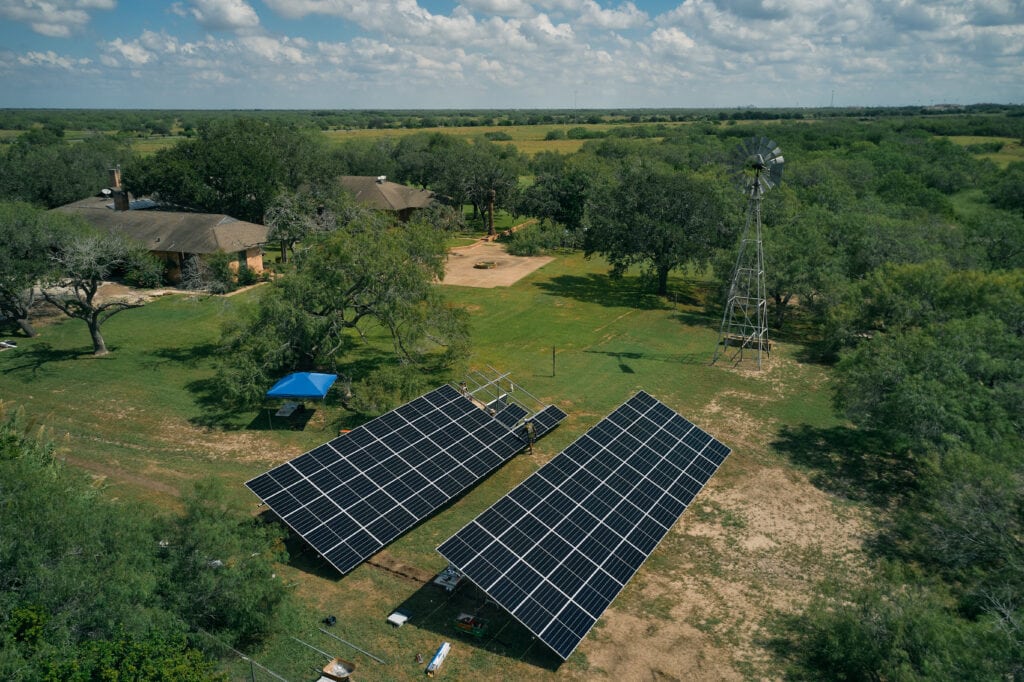 aerial photo of ranch house, south Texas mesquite trees, and ground-mount solar panels