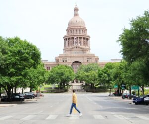 Man walking on a sunny day in front of the Texas capitol