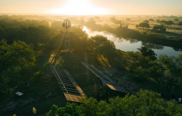 Installation of two solar panels near a lake at sunset