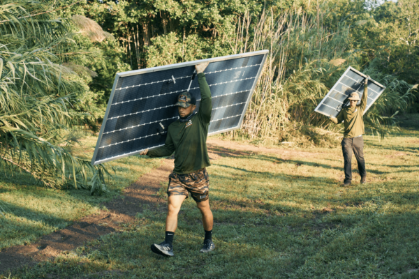 Freedom Solar installers holding panels while walking