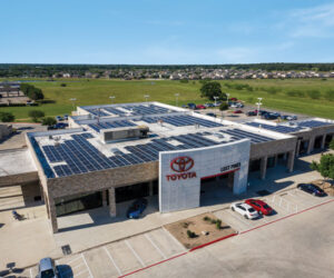 Drone view of Toyota dealership with solar panels installed on the roof and parking lot view