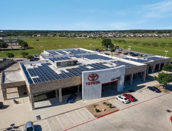 Drone view of Toyota dealership with solar panels installed on the roof and parking lot view