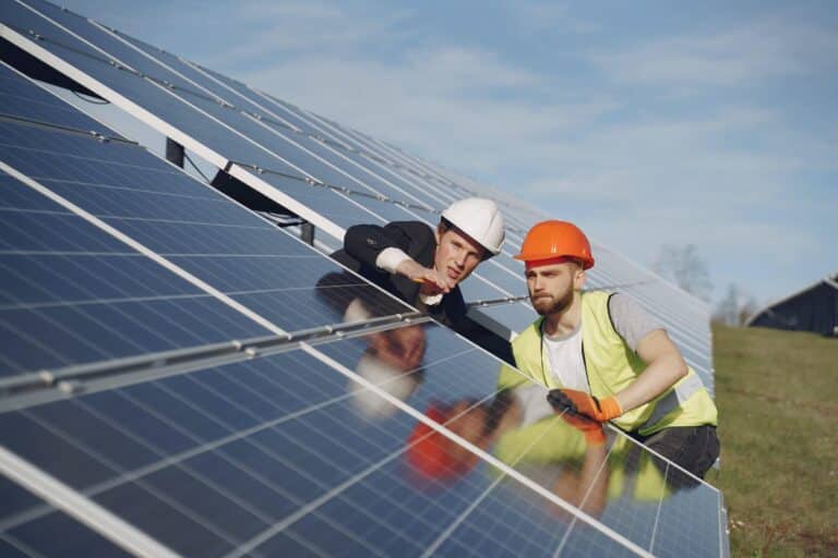 Men working on installation of solar panel over roof