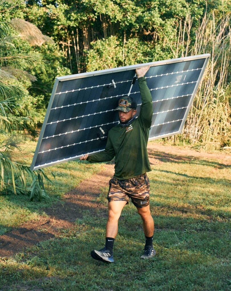 man carrying solar panels