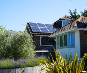 Side view of two residential homes with the furtherest one fastened with a solar panel installation