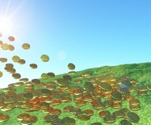 A graphic photo of coins falling out of the sun on top of a rolling green hill.