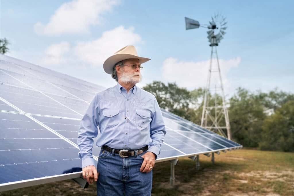 Cowboy on a ranch with solar panels in the background